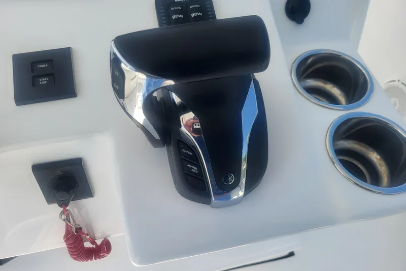 Slide: The Image of Edgewater 245CC 2022 boat control panel with throttle and cup holders. - 51