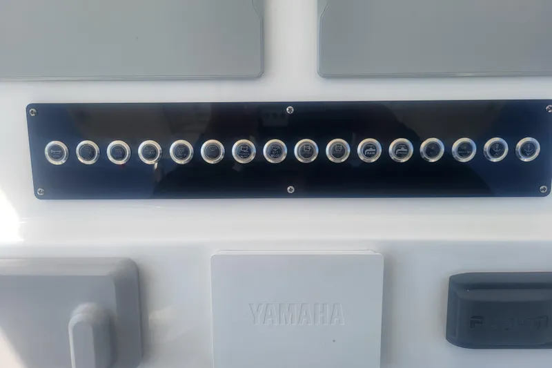 Slide: The Image of Control panel of 2022 Edgewater 245CC boat with labeled buttons and Yamaha branding. - 54