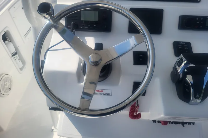 Slide: The Image of Steering wheel and controls of 2022 Edgewater 245CC boat cockpit. - 56