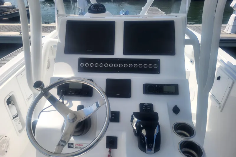 Slide: The Image of Edgewater 245CC 2022 boat dashboard with steering wheel and navigation controls. - 57