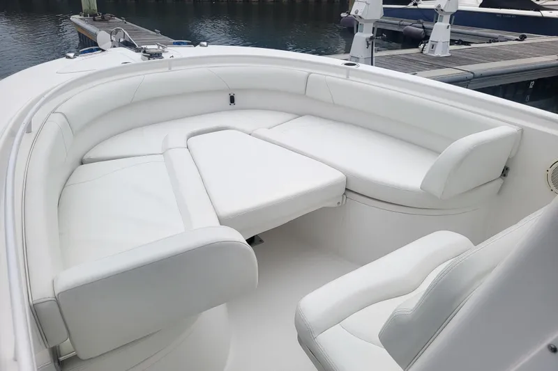Slide: The Image of Luxurious white seating area on 2022 Edgewater 245CC boat, docked at marina. - 61