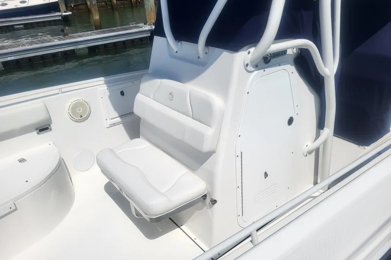 Slide: The Image of 2022 Edgewater 245CC boat interior with white seating and storage compartment. - 8