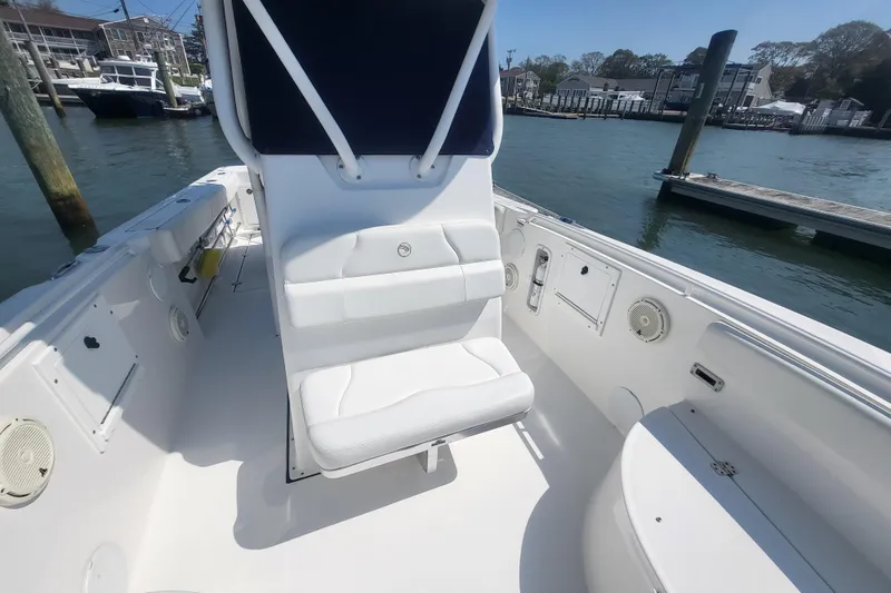 Slide: The Image of 2022 Edgewater 245CC boat interior with seating, docked in a marina. - 9
