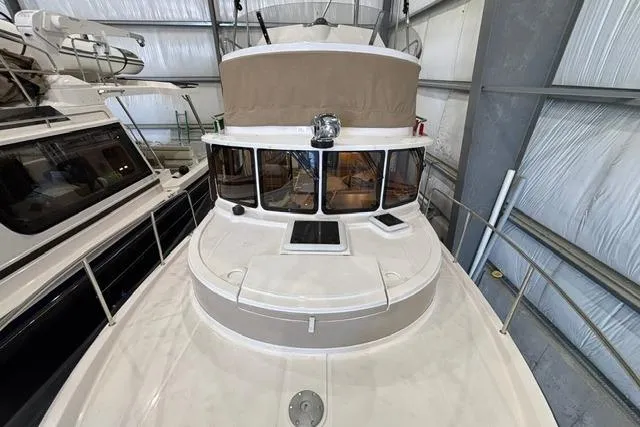Slide: The Image of 2025 Ranger Tugs R-31 CB boat in storage, showcasing upper deck and cabin. - 12