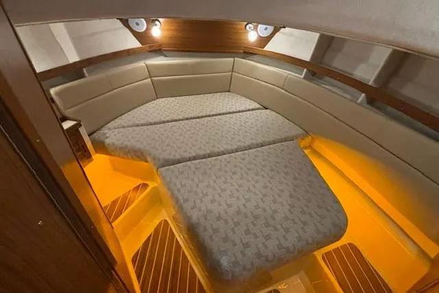 Slide: The Image of 2025 Ranger Tugs R-31 CB cabin interior with cozy seating and warm lighting. - 13