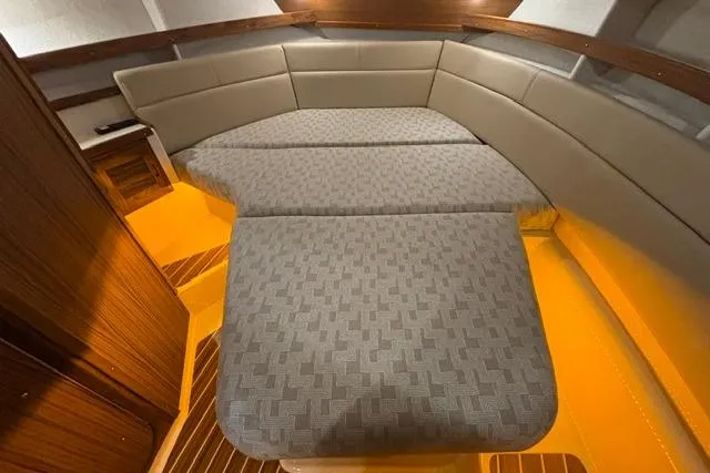 Slide: The Image of Interior of 2025 Ranger Tugs R-31 CB with convertible seating and warm lighting. - 14