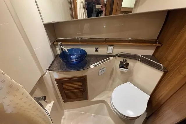 Slide: The Image of Bathroom interior of 2025 Ranger Tugs R-31 CB with modern fixtures and blue glass sink. - 15