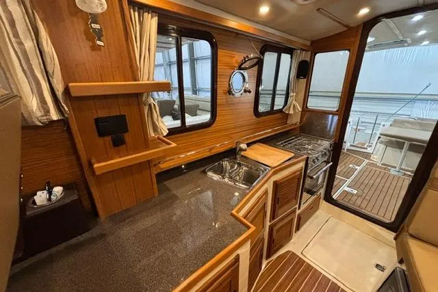 Slide: The Image of Interior of 2025 Ranger Tugs R-31 CB, featuring a modern kitchen and wooden accents. - 19