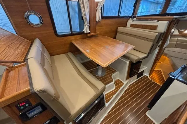 Slide: The Image of Interior of 2025 Ranger Tugs R-31 CB with wood accents and beige seating. - 22