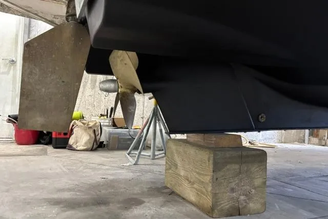 Slide: The Image of 2025 Ranger Tugs R-31 CB boat hull and propeller in a workshop setting. - 25