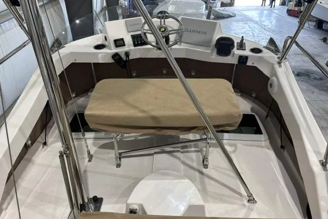Slide: The Image of 2025 Ranger Tugs R-31 CB cockpit with Garmin navigation and cushioned seating. - 3
