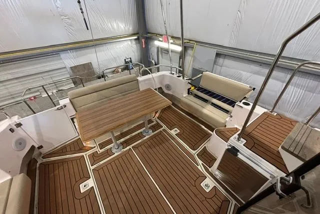 Slide: The Image of 2025 Ranger Tugs R-31 CB boat interior with wood flooring and seating area. - 6