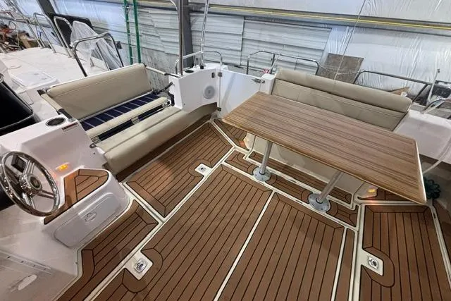 Slide: The Image of 2025 Ranger Tugs R-31 CB boat interior with wood flooring and seating area. - 7