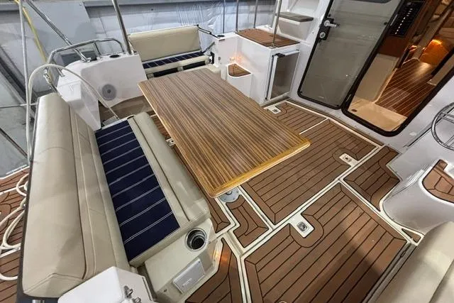 Slide: The Image of 2025 Ranger Tugs R-31 CB interior with wood flooring and seating area. - 9