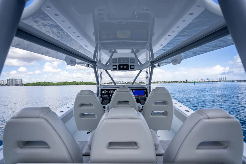 Slide: The Image of Interior view of 2020 Freeman 42LR boat with modern dashboard and ocean backdrop. - 13