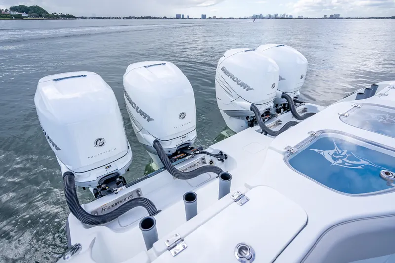 Slide: The Image of Four Mercury outboard engines on a 2020 Freeman 42LR boat, cruising on calm waters. - 19