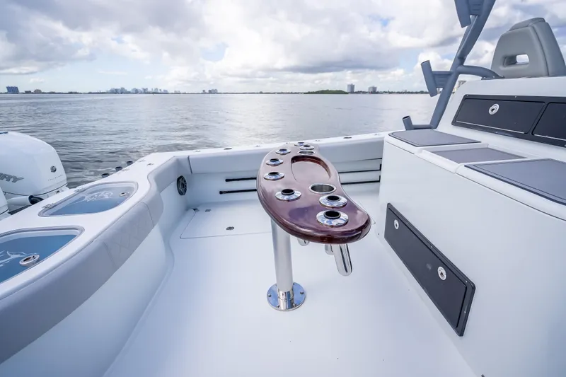 Slide: The Image of 2020 Freeman 42LR boat deck with rod holders, overlooking calm waters and distant skyline. - 22