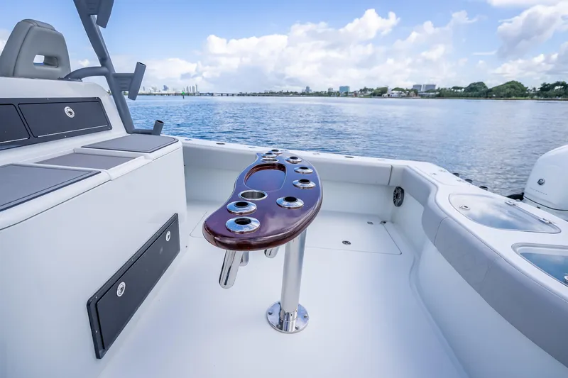 Slide: The Image of 2020 Freeman 42LR boat interior with rod holders, overlooking calm waters and distant cityscape. - 23