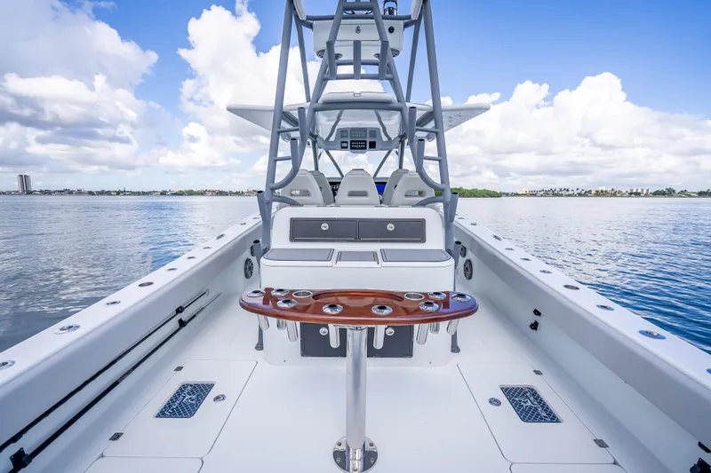 Slide: The Image of 2020 Freeman 42LR boat interior with fishing rod holders, on calm water under blue sky. - 25