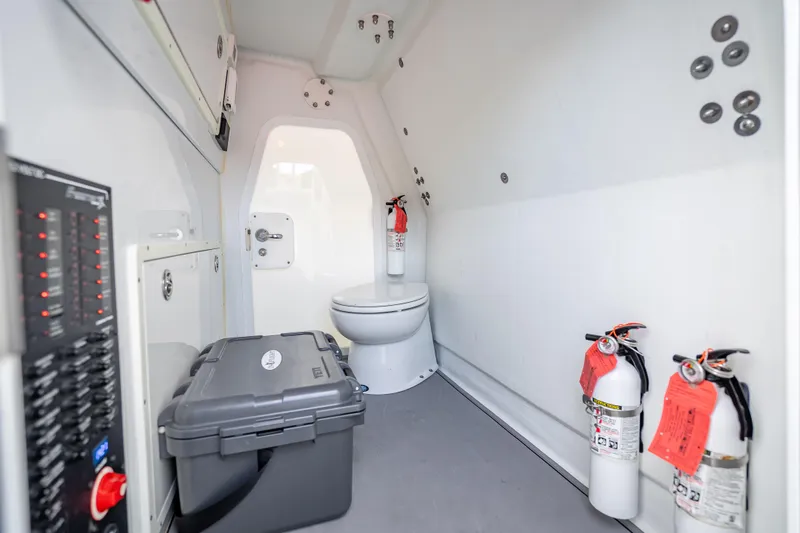 Slide: The Image of Interior of a 2020 Freeman 42LR boat featuring a toilet, fire extinguishers, and storage box. - 7