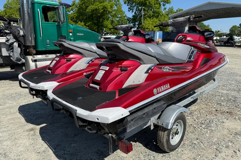 Slide: The Image of Red 2013 Yamaha WaveRunner FX HO jet skis on a trailer, parked outdoors. - 2