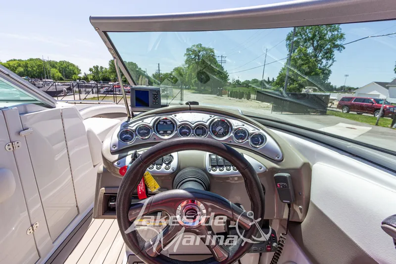 Slide: The Image of 2008 Crownline 240 LS boat dashboard with steering wheel and gauges in marina setting. - 20