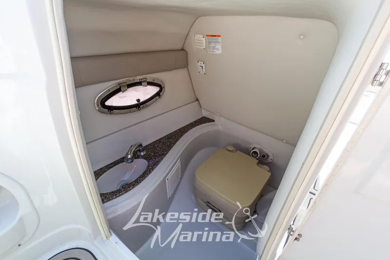 Slide: The Image of 2008 Crownline 240 LS boat interior bathroom with sink and portable toilet. - 27