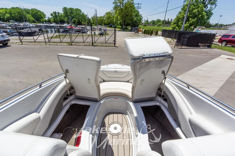 Slide: The Image of 2008 Crownline 240 LS boat interior with open storage compartments, parked outdoors. - 35