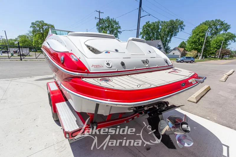 Slide: The Image of 2008 Crownline 240 LS boat with red and white design, parked on a trailer. - 4