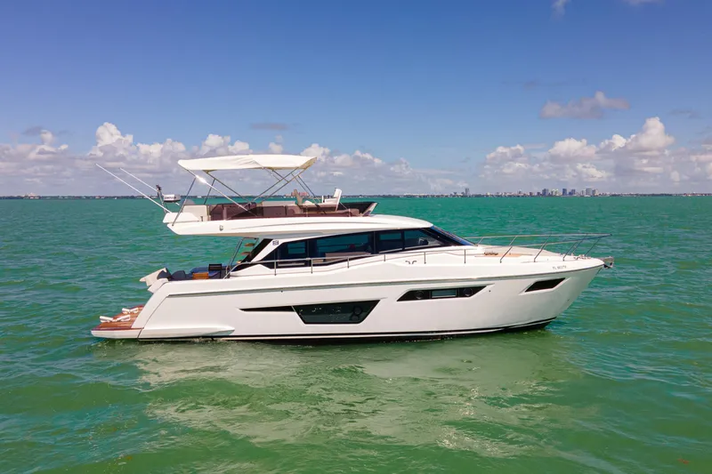Slide: The Image of 2022 Ferretti Yachts 500 cruising on calm green waters under a clear blue sky. - 17
