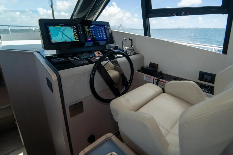 Slide: The Image of Helm of 2022 Ferretti Yachts 500 with navigation screens and leather seating. - 27