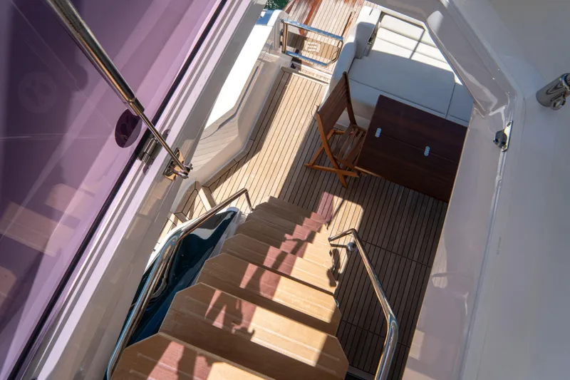 Slide: The Image of Staircase view on 2022 Ferretti Yachts 500, featuring elegant wooden deck and seating area. - 49