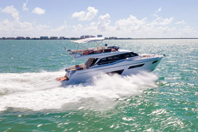 Slide: The Image of 2022 Ferretti Yachts 500 cruising on open water under a clear sky. - 9