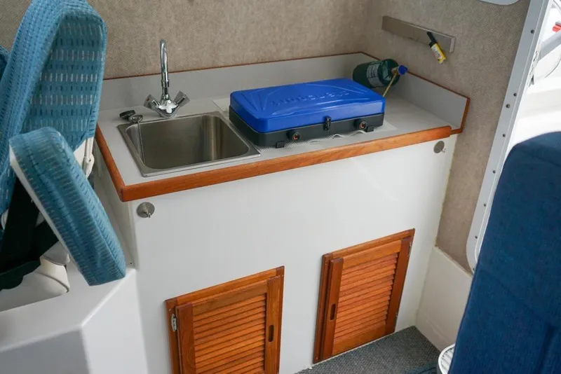 Slide: The Image of Compact kitchenette in 2021 Sea Sport Explorer 2400 with sink and stove. - 10