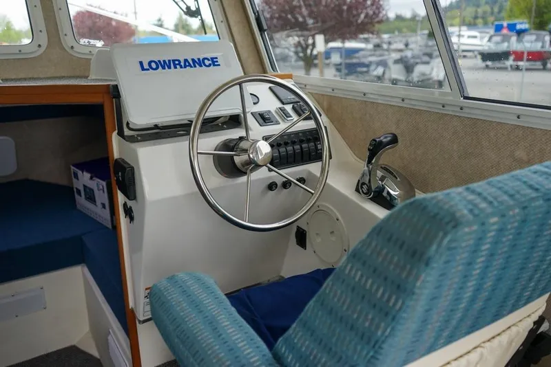 Slide: The Image of Interior of a 2021 Sea Sport Explorer 2400 boat with steering wheel and navigation equipment. - 11