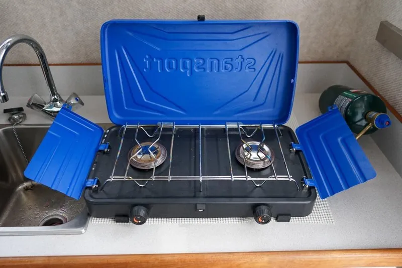 Slide: The Image of Portable camping stove on Sea Sport Explorer 2400 boat, 2021 model, with blue lid and propane tank. - 18