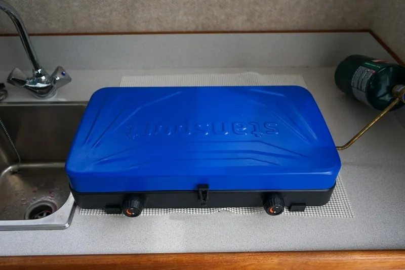 Slide: The Image of Blue portable stove on a countertop in a Sea Sport Explorer 2400 boat kitchen. - 19