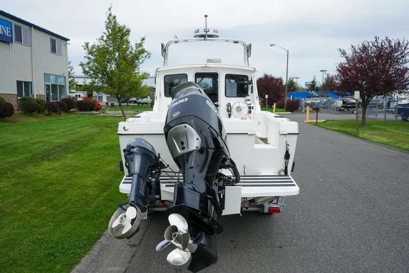 Slide: The Image of 2021 Sea Sport Explorer 2400 boat with dual outboard motors on a street. - 3