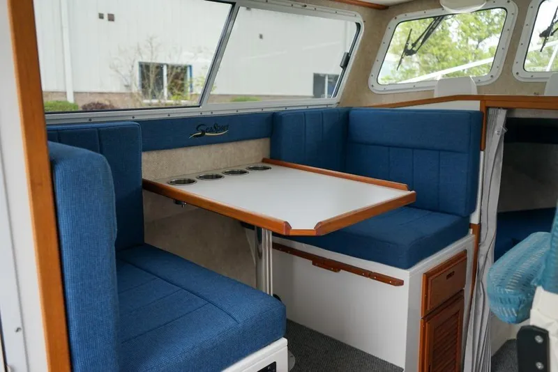 Slide: The Image of Interior of 2021 Sea Sport Explorer 2400 with blue seating and a white table. - 9