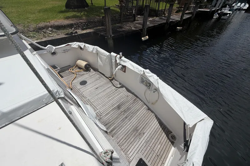 Slide: The Image of 1991 Grand Banks 46 Classic yacht deck with wooden flooring and dockside view. - 10