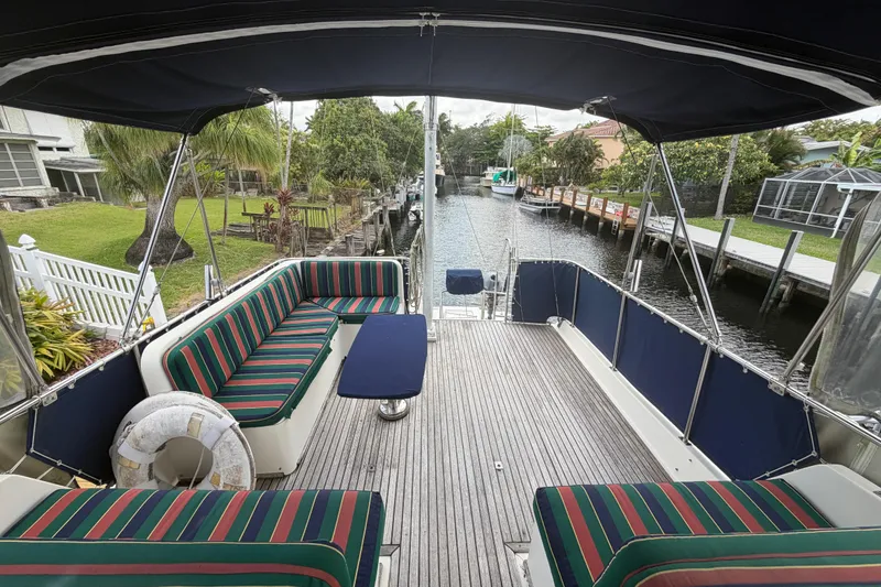 Slide: The Image of Grand Banks 46 Classic 1991 yacht deck with striped seating and canal view. - 15