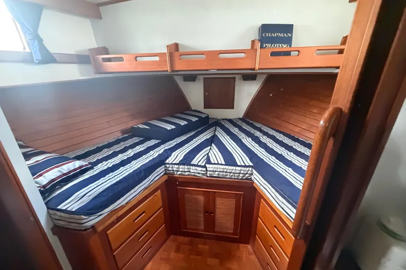 Slide: The Image of Cozy cabin interior of 1991 Grand Banks 46 Classic yacht with striped bedding. - 24