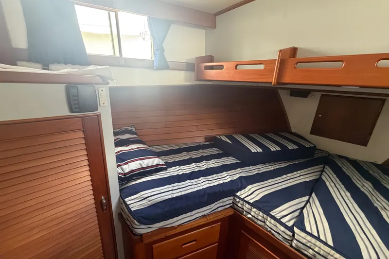Slide: The Image of Cozy cabin interior of 1991 Grand Banks 46 Classic with striped bedding and wooden accents. - 25