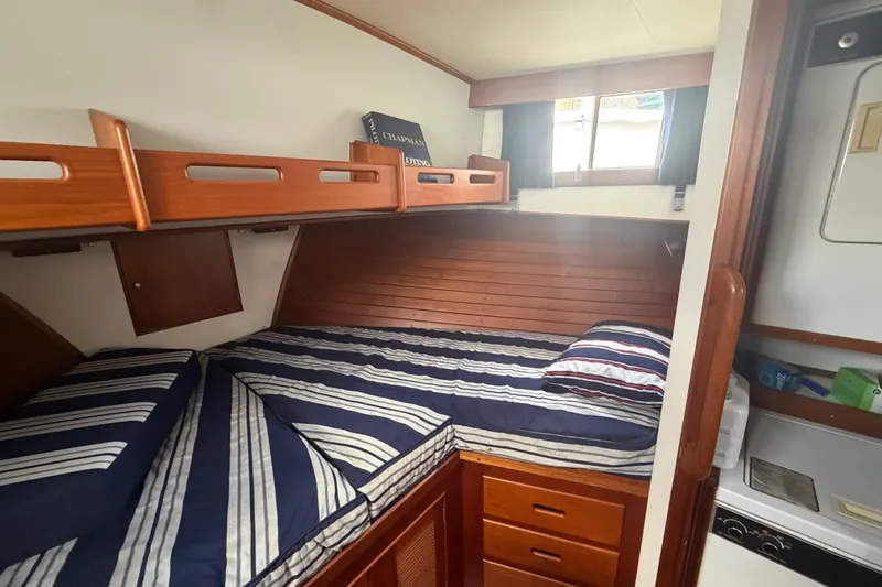 Slide: The Image of Cozy cabin interior of 1991 Grand Banks 46 Classic yacht with striped bedding. - 26