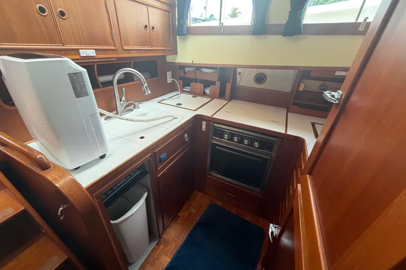 Slide: The Image of 1991 Grand Banks 46 Classic yacht kitchen with wooden cabinetry and modern appliances. - 29