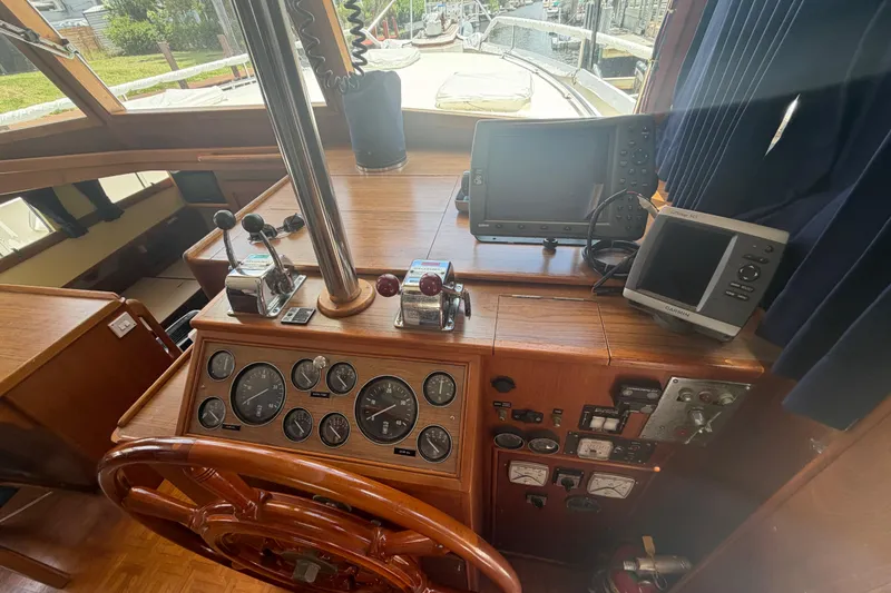 Slide: The Image of 1991 Grand Banks 46 Classic helm with navigation instruments and wooden steering wheel. - 31