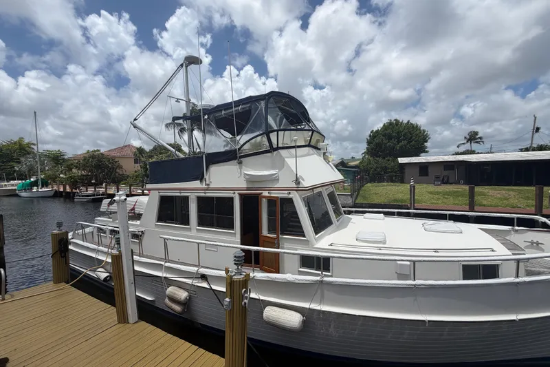 Slide: The Image of 1991 Grand Banks 46 Classic yacht docked under a cloudy sky. - 35