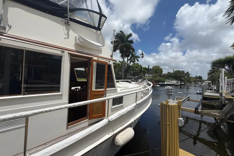 Slide: The Image of 1991 Grand Banks 46 Classic yacht docked by a scenic waterway. - 38