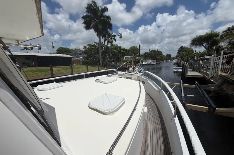 Slide: The Image of 1991 Grand Banks 46 Classic yacht docked by a scenic canal under a partly cloudy sky. - 4