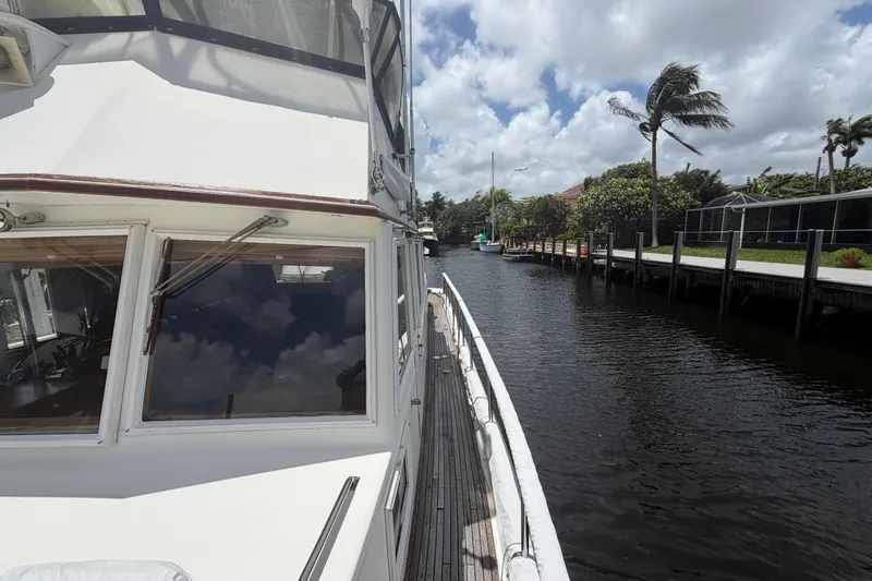 Slide: The Image of 1991 Grand Banks 46 Classic yacht docked by a scenic canal under a cloudy sky. - 8